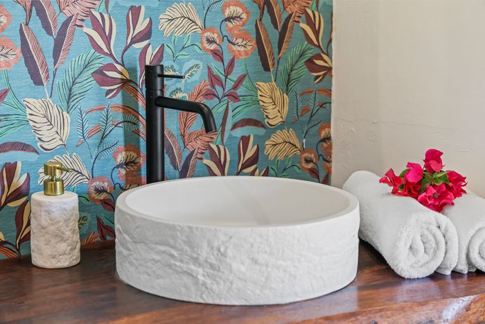 Stone basin against flowered wallpaper