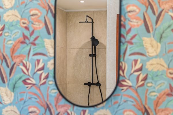 Shower against flowered wallpaper