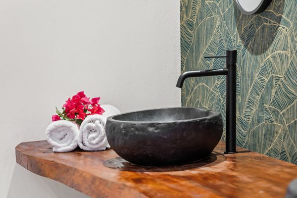 Stone basin against green wallpaper