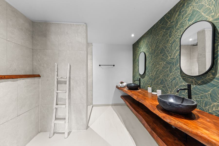 Badkamer met groen botanisch behang en stenen waskom